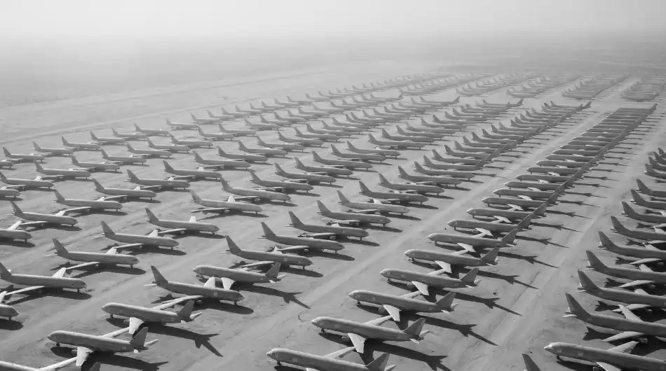 Rows of stored aircraft at a desert storage facility, seen from the air